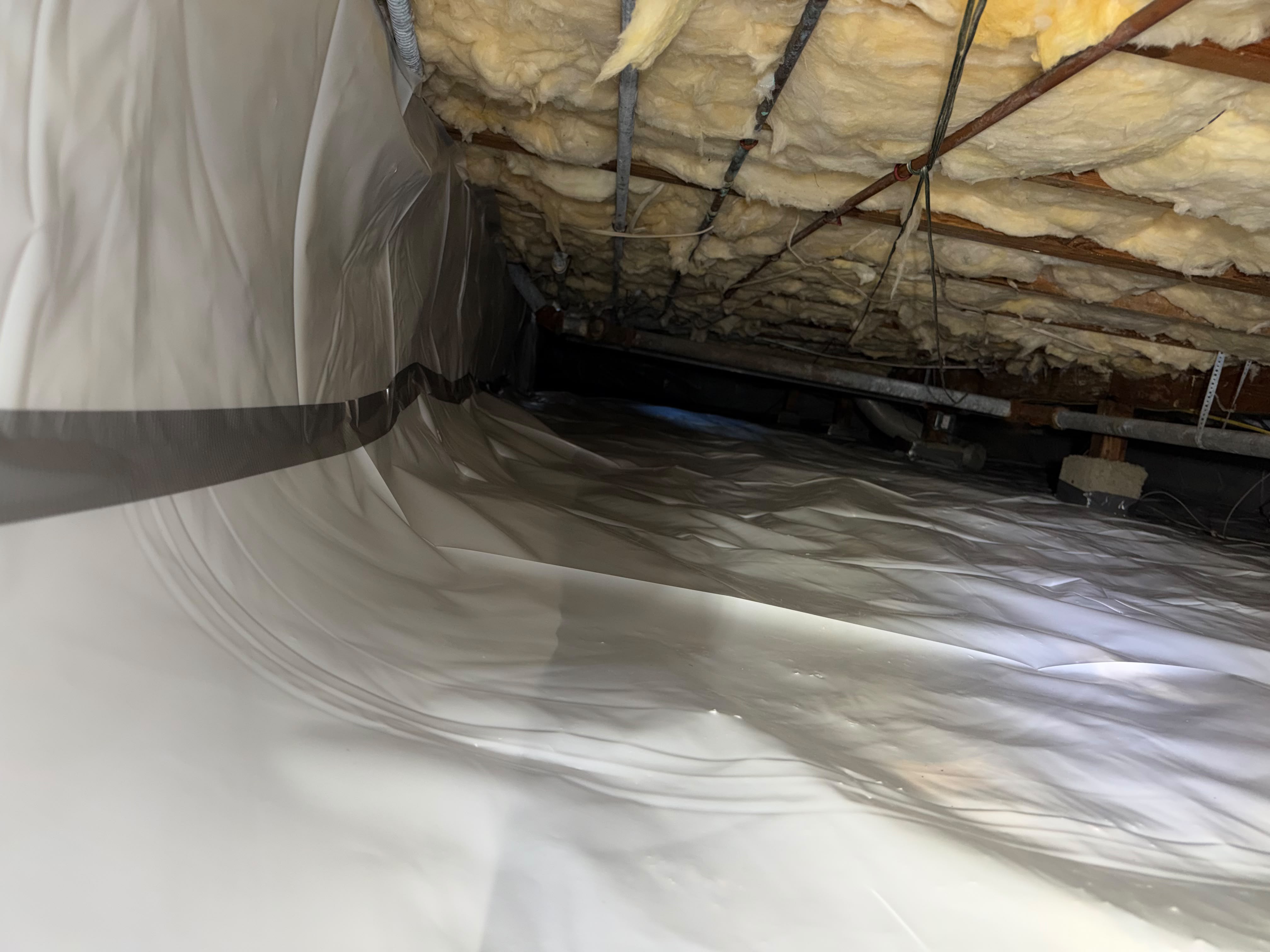 Crawl space with white vapor barrier and insulation